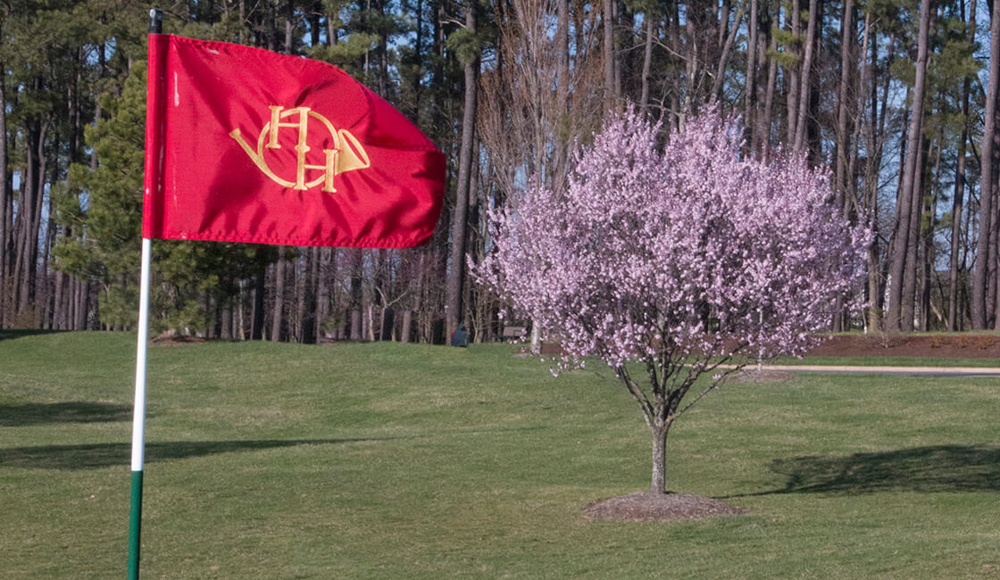 red golf flag with Heritage Hunt Golf Club logo